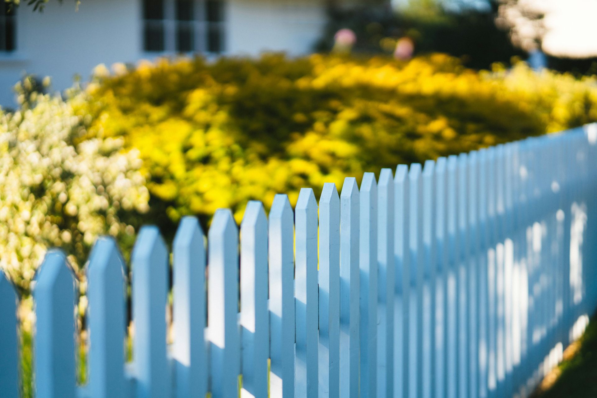 A white picket fence in front of a house